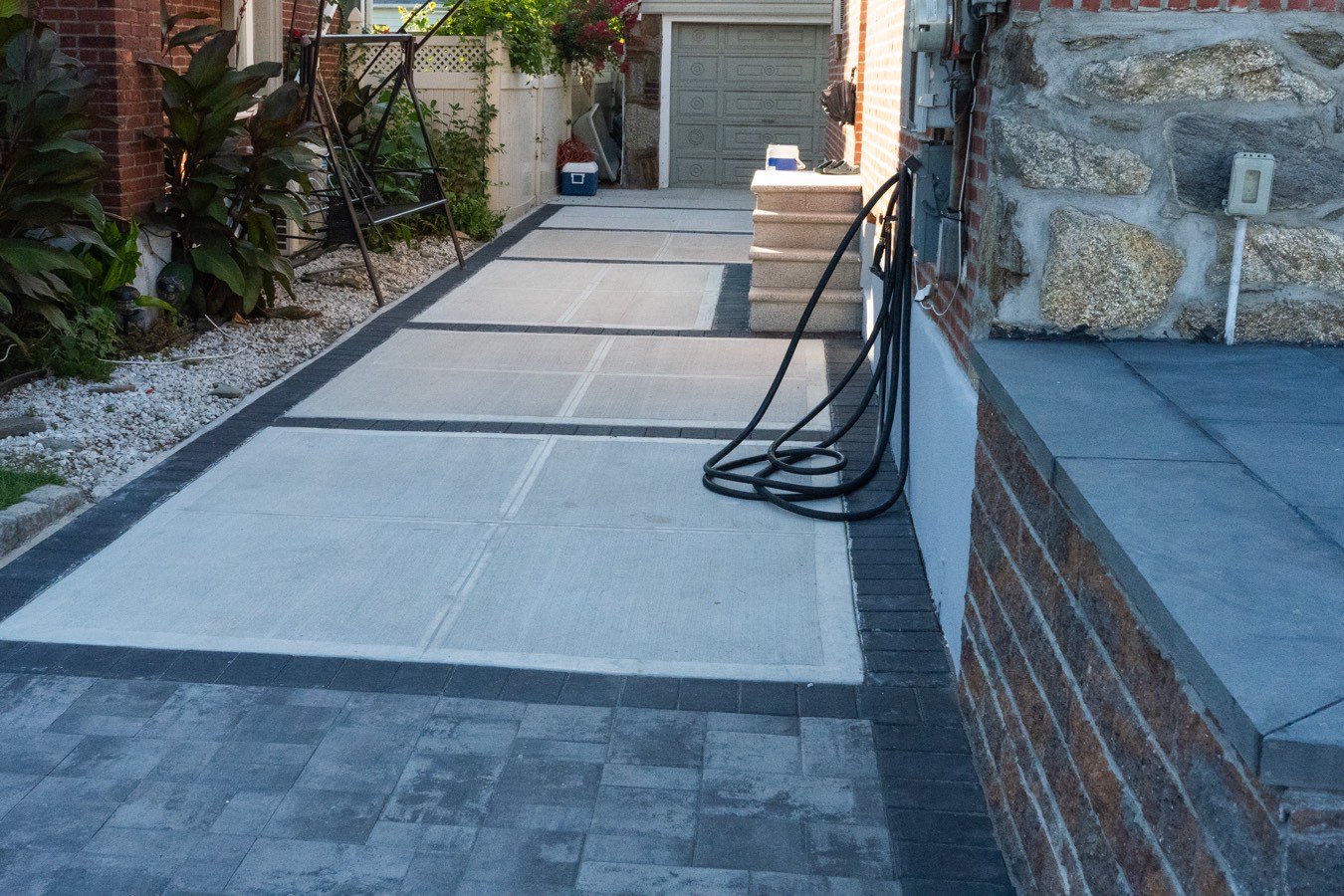 Concrete driveway with paver border by SJNY